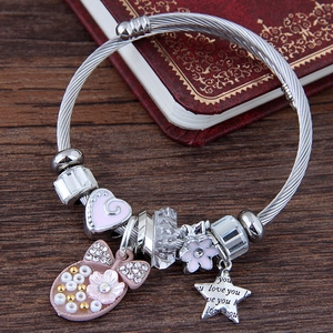 Silbernes Charm-Armband mit Herz- und Sternanhängern vor einem Vintage-Hintergrund