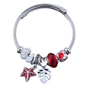 Silver twisted cable bracelet with red crystal starfish and monstera leaf pendants