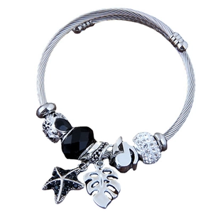 Silver stainless steel wire bracelet featuring starfish, leaf, and music note charms