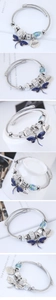 Détail du bracelet en fil d'argent avec breloque libellule émaillée bleue et perles