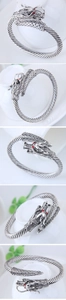 Detailed close-up of a vintage dragon cuff bracelet with red eyes and twisted band