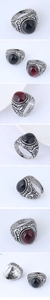 Macro detail of retro engraved metal ring featuring black and red oval gemstones