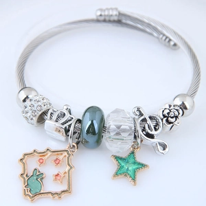 Makro-Detail des silbernen Charm-Armbands mit blauen Emailleperlen und Hasenstern-Anhänger
