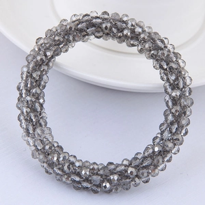 Vue détaillée des perles de cristal gris à facettes tissées sur un bracelet élastique