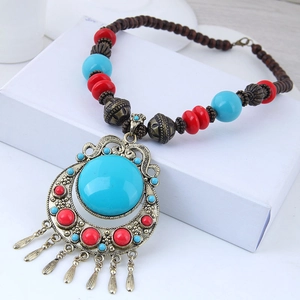 Close-up of Bohemian ethnic necklace with blue stone pendant and vintage bronze tassels