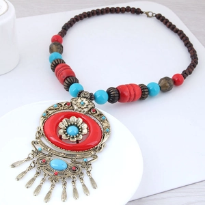 Detail of bohemian long beaded necklace with red turquoise beads and bronze fringe