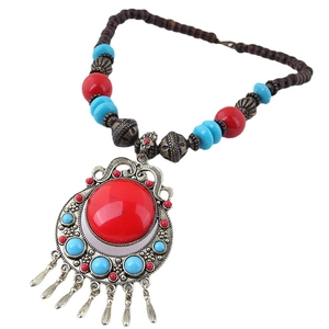 Ethnic bohemian necklace with red blue beads and vintage bronze bells on white background