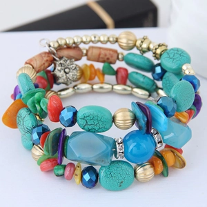 Détail d'un bracelet multicouche bohème avec perles turquoise et breloque fleurie en métal