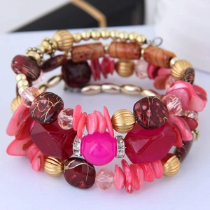 Détail d'un bracelet multi-rangs bohème avec perles de cristal rouges et coquillages