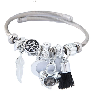 Bracelet câble argenté avec breloques plume, arbre de vie, lune, cœur et pompon noir
