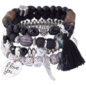Bohemian multilayer beaded bracelet set with black tassels and silver charms on white background