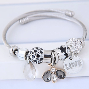 Silver steel cable bracelet with bee crystal pendant and engraved LOVE charm on white base