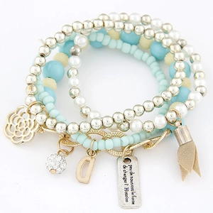 Detail of multi-layer beaded bracelet featuring cat eye beads and rose charm
