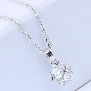 Macro view of silver necklace featuring a cube pendant set with sparkling cubic zirconia