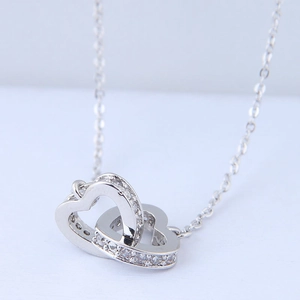 Macro detail of interlocking double heart pendant necklace with shimmering zircon stones