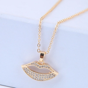 Golden necklace with a zircon-encrusted hollow lip pendant and fine chain on a light background