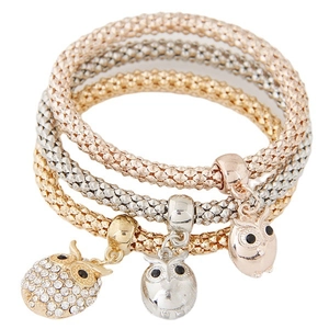 Lot de trois bracelets pendentifs hibou en or, argent et or rose avec chaîne maille