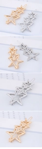 Detail of overlapping hollow five-pointed star hair clips in gold and silver metal finish