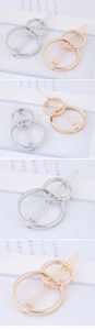 Close-up of geometric circular metal hair clips showing gold and silver plating details