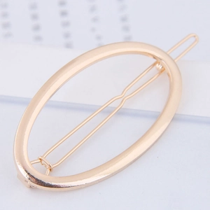 Polished gold alloy oval hair clip with minimalist geometric design on card
