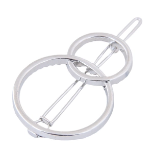 Minimalist silver metal hair clip with geometric double circle design on white background