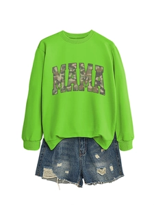 Flat lay of neon green MAMA sweatshirt with camo print and frayed denim shorts
