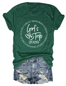 Flat lay of a dark green crew neck t-shirt with Girl's Trip 2026 print and denim shorts