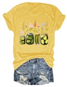 Détail d'un t-shirt jaune avec imprimé floral de cornichons et short en jean bleu