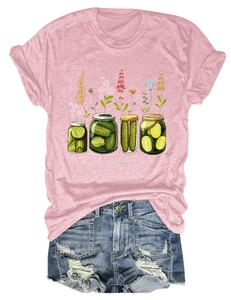 Détail d'un t-shirt rose en coton avec motif bocaux à fleurs et short en jean déchiré