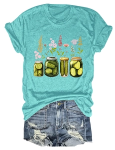 Détail de l'illustration artistique de cornichons et fleurs sur T-shirt turquoise