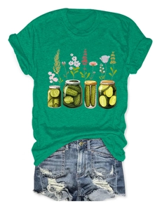 T-shirt vert imprimé fleurs de concombre posé à plat avec un short en jean usé