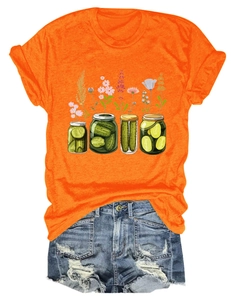 Gros plan d'un t-shirt orange avec imprimé floral de bocaux et un short en jean déchiré