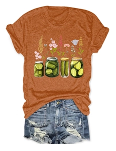 Détail à plat d'un t-shirt orange à motif floral et d'un short en jean effiloché
