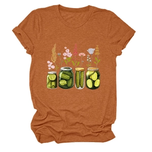 Détail d'un t-shirt orange rouille avec motif graphique de bocaux de cornichons et fleurs