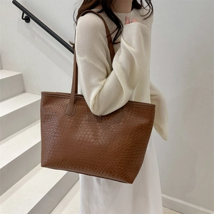 Brown woven leather tote bag with large capacity for commuting shown on a model