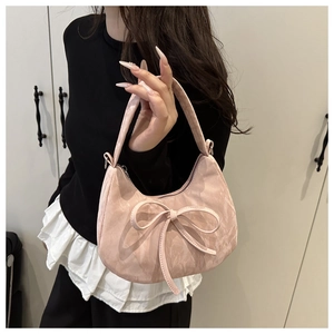 Detail of pink pleated crescent handbag featuring a delicate ribbon bow and marble texture