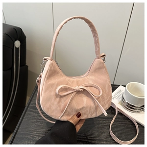 Detail of pink hobo bag with bow decoration and pleated texture on artistic background
