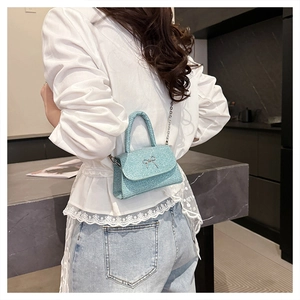 Close-up of glittery light blue crossbody bag with a silver metal bow buckle detail