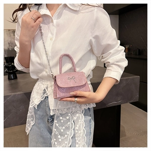 Detailed shot of a pink sequin mini bag featuring a silver bow and delicate chain strap
