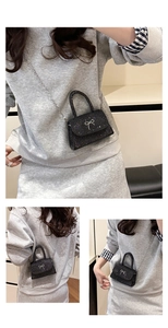 Detail of black sequined mini bag featuring silver bow accent and metal chain strap