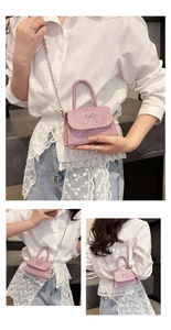 Close-up of pink glitter mini bag with silver bow detail and metal chain strap