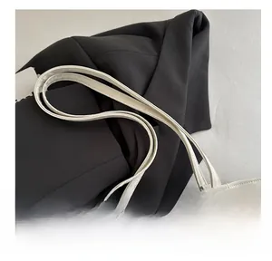 Detailed close-up of soft faux leather handles and zipper on a cream tote bag