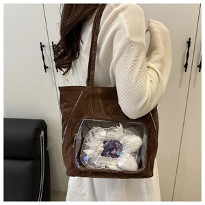 Detail of dark brown ita bag featuring a clear PVC window and wrinkled fabric texture