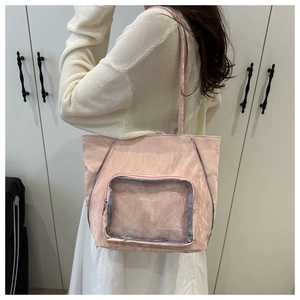 Pink tote bag detail featuring a transparent PVC front pocket and soft pleated texture