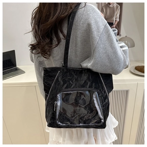 Detail of black pleated tote bag showing large capacity, PVC pocket and silver zippers