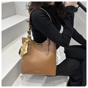 Detail of caramel leather tote bag with decorative silk scarf and FASHION & BAGS text