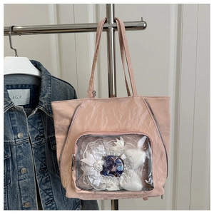 Detailed view of pink pleated tote bag with clear window and heart pearl button