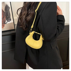 Mini yellow crescent bag in premium matte finish styled on a black blazer outfit