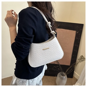 Vue détaillée du sac sous le bras en cuir tressé blanc avec boucle dorée et bandoulière