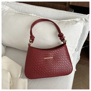 Détail du sac hobo bordeaux avec texture tissée, bandoulière nouée et détails dorés